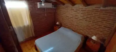 a small room with a bed and a brick wall at Cabañas Dionisio in Nono