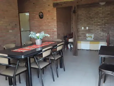a room with a table and chairs and a bed at Viejo Algarrobo Villa Amancay Calamuchita in Villa Amancay