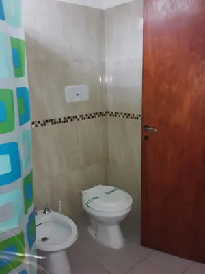 a bathroom with a toilet and a sink at Viejo Algarrobo Villa Amancay Calamuchita in Villa Amancay