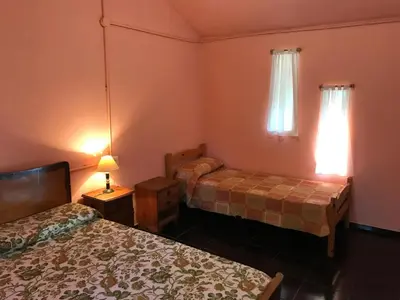 a bedroom with two beds and a lamp on a table at Cometierra, casa de campo in Panaholma