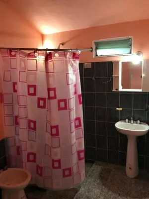 a bathroom with a shower curtain and a sink at Cometierra, casa de campo in Panaholma