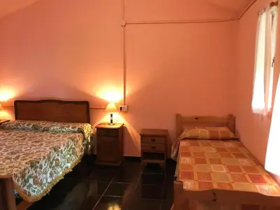 a bedroom with two beds and a table and two lamps at Cometierra, casa de campo in Panaholma