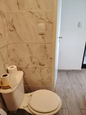 a bathroom with a white toilet and a marble wall at Casa Puerto del Águila Potrero de Garay in La Estancia