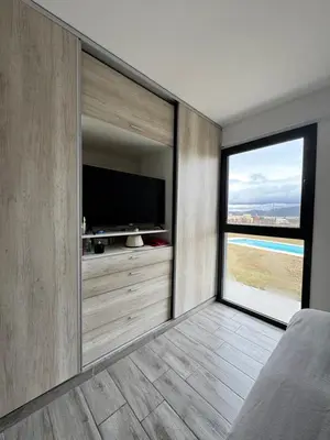 a bedroom with a flat screen tv and a large window at Casa Puerto del Águila Potrero de Garay in La Estancia