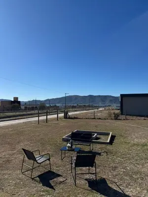 two chairs and a table in a field at Casa Puerto del Águila Potrero de Garay in La Estancia