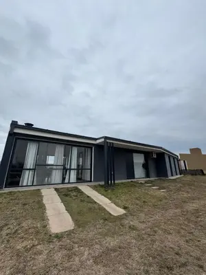 a black house on top of a grass field at Casa Puerto del Águila Potrero de Garay in La Estancia