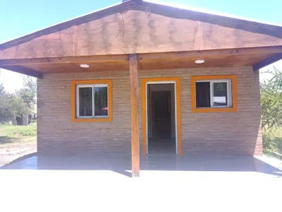 a small brick house with a wooden roof at Cabaña Mi Sol in Villa del Dique