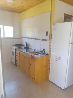 a kitchen with a sink and a refrigerator at Cabaña Mi Sol in Villa del Dique