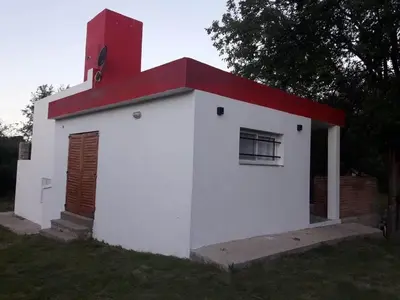 a small white building with a red roof at Casa en Traslasierra in Los Hornillos