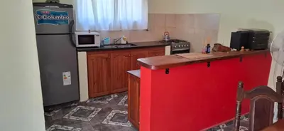 a kitchen with a refrigerator and a red island in it at Casa en Traslasierra in Los Hornillos