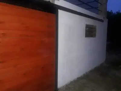 a white wall with a wooden garage door at Casa en Traslasierra in Los Hornillos