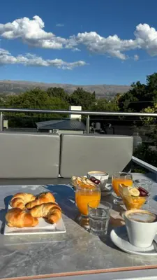 a table with two plates of croissants and orange juice at Sol del Valle in Mina Clavero
