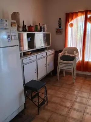 a kitchen with a refrigerator and a table and chairs at Los Bubos in Villa Los Aromos