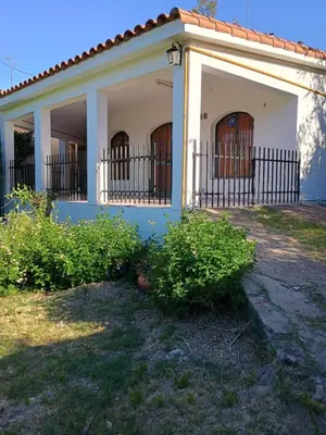 a house with two doors and a fence at Los Bubos in Villa Los Aromos