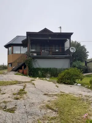 a house with a porch and a balcony at Cabañas El Mirador in Calmayo