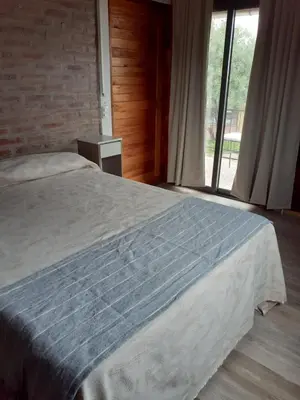 a bedroom with a bed and a large window at Cabañas El Mirador in Calmayo