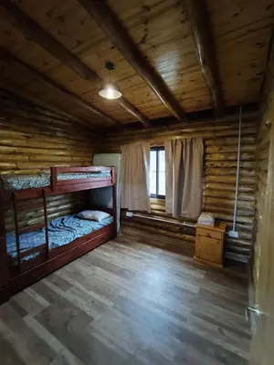 a room with two bunk beds in a log cabin at Cabaña de montaña in Villa Yacanto