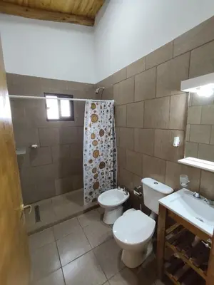 a bathroom with two toilets and a sink at Cabaña de montaña in Villa Yacanto