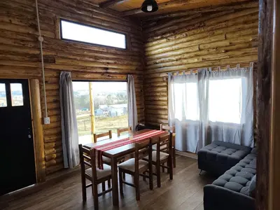 a dining room with a table and chairs and a window at Cabaña de montaña in Villa Yacanto