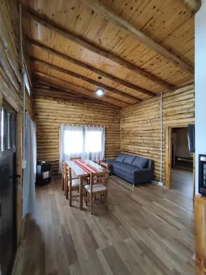 a living room with a table and a couch at Cabaña de montaña in Villa Yacanto