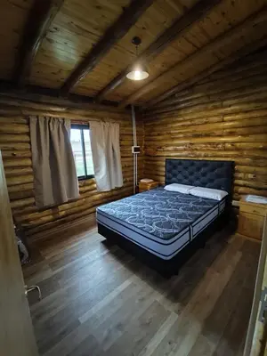 a bedroom with a bed in a log cabin at Cabaña de montaña in Villa Yacanto
