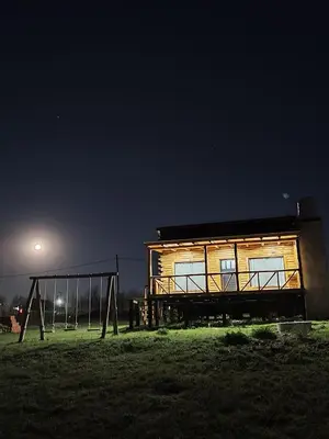 a cabin in a field at night with the moon at Cabaña de montaña in Villa Yacanto