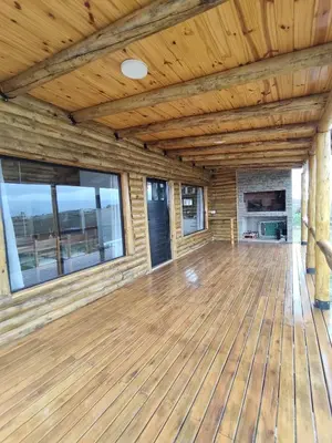 a large room with wood floors and windows at Cabaña de montaña in Villa Yacanto