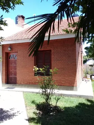a red brick house with a red door at Marta y Chiche in Mina Clavero