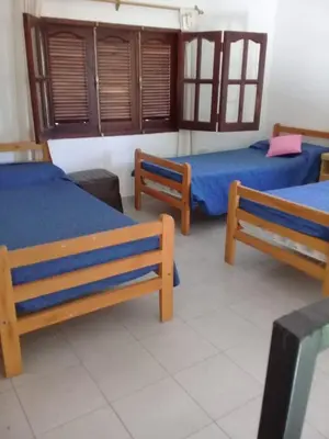 a room with three beds with blue sheets at Marta y Chiche in Mina Clavero
