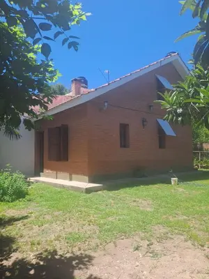 a brick house with a grass yard in front of it at Marta y Chiche in Mina Clavero