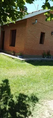 a brick building with windows and a field of grass at Marta y Chiche in Mina Clavero
