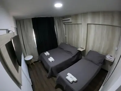 a small room with two beds and a table at LakeHouse Hotel & Suites in Villa Carlos Paz