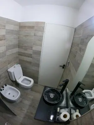 a bathroom with a toilet and a sink and a mirror at LakeHouse Hotel & Suites in Villa Carlos Paz