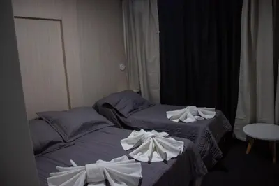 two beds in a hotel room with towels on them at LakeHouse Hotel & Suites in Villa Carlos Paz