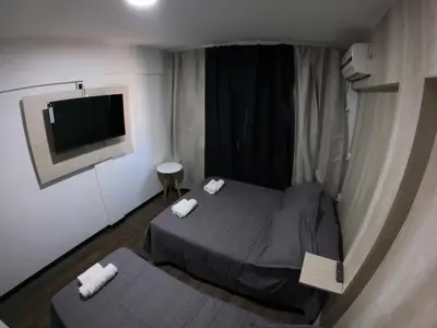 a small room with two beds and a flat screen tv at LakeHouse Hotel & Suites in Villa Carlos Paz