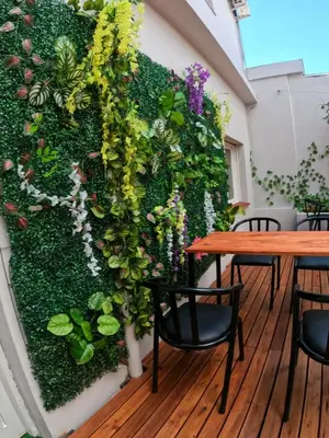 a wall covered in ivy with tables and chairs at LakeHouse Hotel & Suites in Villa Carlos Paz