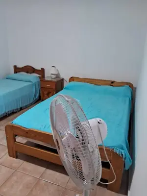 a white fan in a room with a bed at Marta y Chiche in Mina Clavero