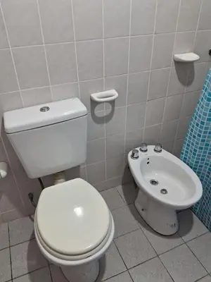 a bathroom with a white toilet and a sink at Marta y Chiche in Mina Clavero