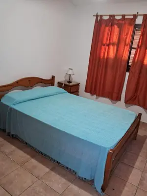 a bedroom with a bed with a blue blanket on it at Marta y Chiche in Mina Clavero