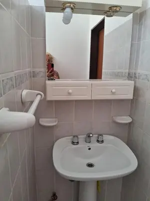 a bathroom with a white sink and a mirror at Marta y Chiche in Mina Clavero