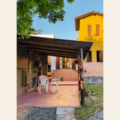 a patio with a pergola in front of a house at Casa con pileta exclusiva Mina Clavero in Mina Clavero