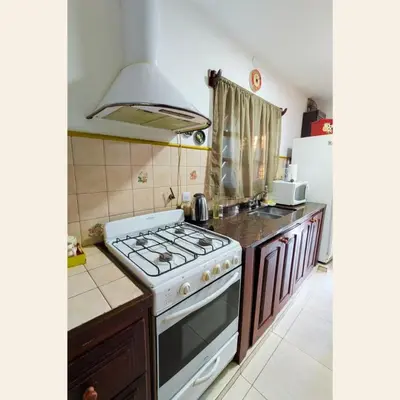 a kitchen with a stove and a refrigerator at Casa con pileta exclusiva Mina Clavero in Mina Clavero