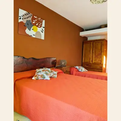 a bedroom with two beds with orange sheets at Casa con pileta exclusiva Mina Clavero in Mina Clavero