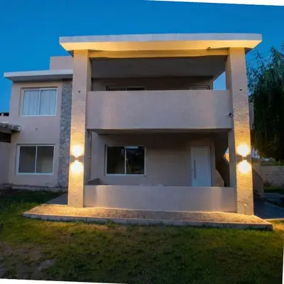 a house with lights on the side of it at Casa Olivia - Alquiler temporario en Tanti in Tanti