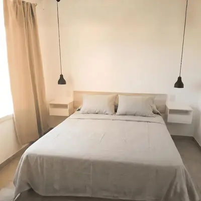a bedroom with a large bed with two pendant lights at Casa Olivia - Alquiler temporario en Tanti in Tanti