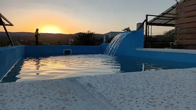 a swimming pool with a water fountain on a building at Cabañas El Molle in Cavalango