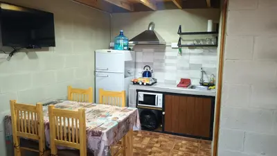 a kitchen with a table and a white refrigerator at Cabañas El Molle in Cavalango