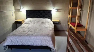a bedroom with a bed with a white comforter at Cabañas El Molle in Cavalango