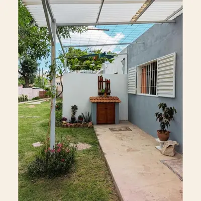 a backyard with a white wall and a wooden door at Lo de Juany in Villa Cura Brochero