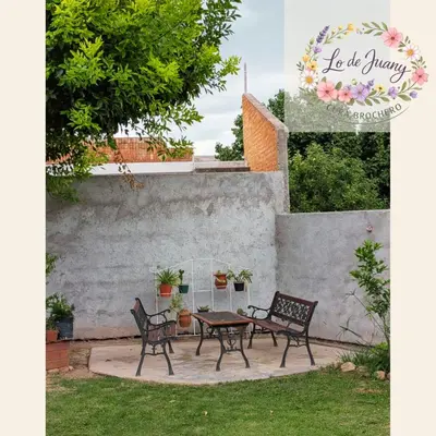 a patio with two chairs and a table at Lo de Juany in Villa Cura Brochero
